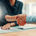 Two people shaking hands in an office
